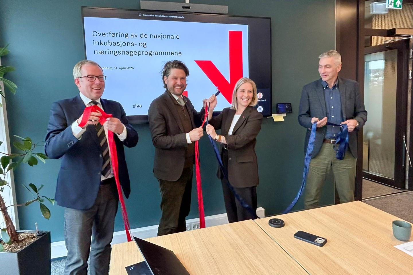 Snorknyting for næringshagene og inkubatorene, der rødt representerer Innovasjon Norge og blått representerer Siva. Markeringen ble foretatt av administrerende direktør Håkon Haugli i Innovasjon Norge (f.v.), statssekretær Vegard Grøslie Wennesland i Nærings- og fiskeridepartementet, statssekretær Sigrid Ina Simonsen i Kommunal- og distriktsdepartementet og administrerende direktør Jan Morten Ertsaas i Siva. © Ingrid Langerud / Innovasjon Norge
